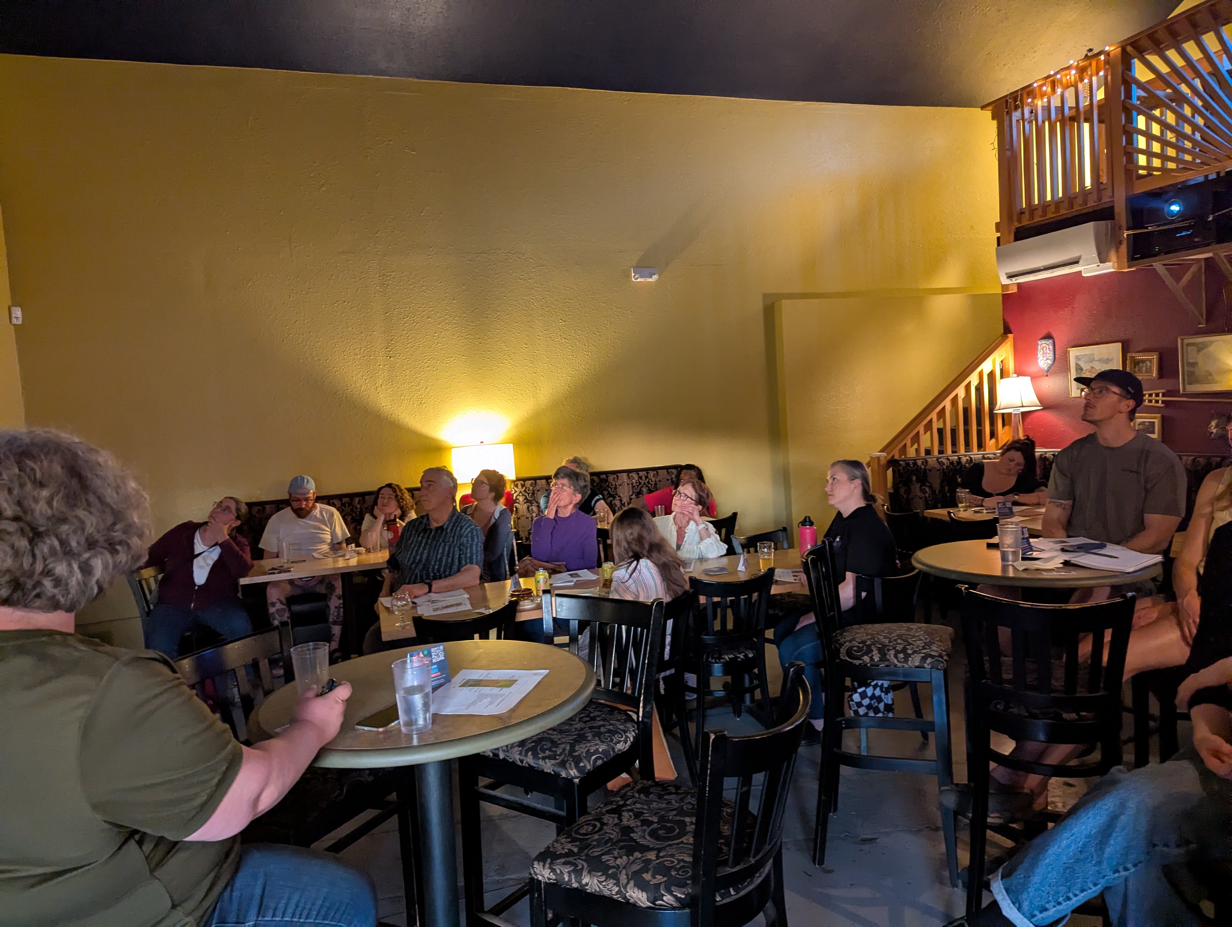 A room full of people all looking intently up towards the projected screen